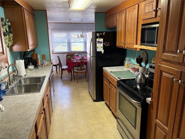 kitchen featuring pendant lighting, sink, stainless steel appliances, and a chandelier