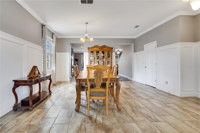 dining area with ornamental molding and a notable chandelier