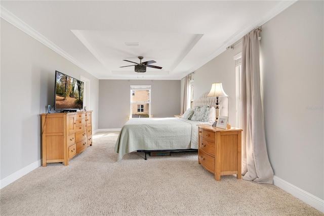 carpeted bedroom featuring ornamental molding, ceiling fan, and a raised ceiling