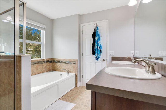 bathroom with tile patterned floors, vanity, and a tub to relax in