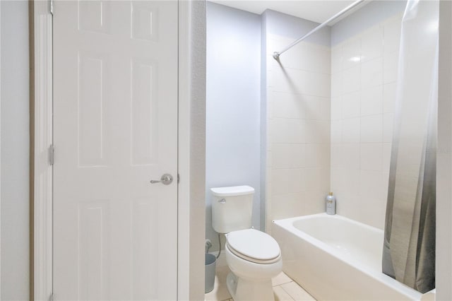 bathroom featuring toilet, tile patterned floors, and  shower combination