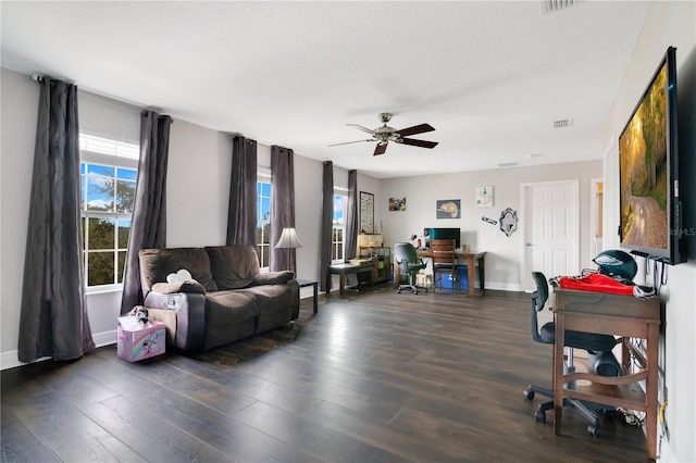 living room featuring ceiling fan, dark wood-type flooring, and a textured ceiling