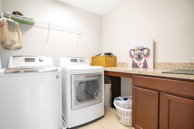 clothes washing area featuring light tile patterned flooring, sink, cabinets, and independent washer and dryer