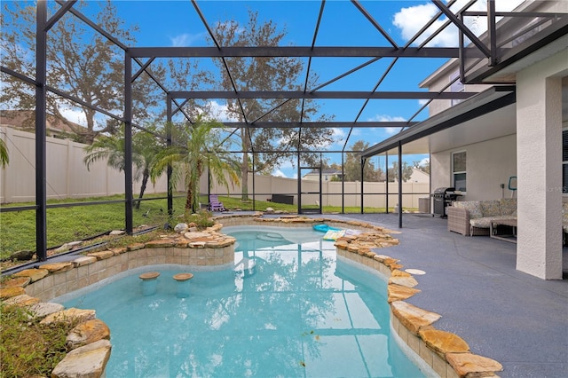 view of pool with glass enclosure, a patio area, and area for grilling