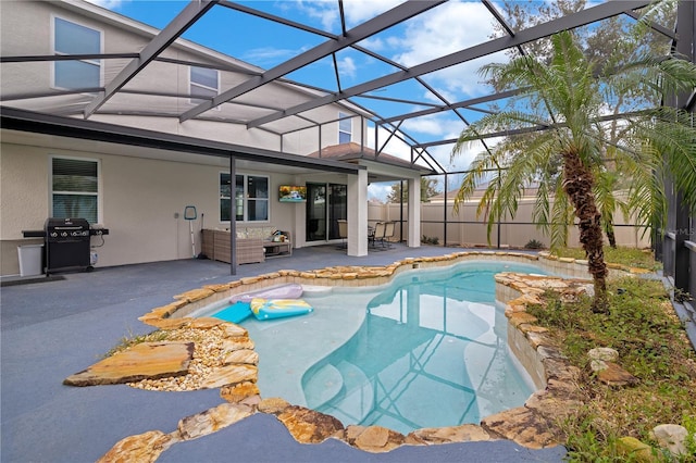 view of pool with glass enclosure, a patio, and area for grilling