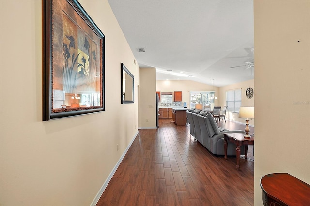 hall with lofted ceiling and dark hardwood / wood-style floors