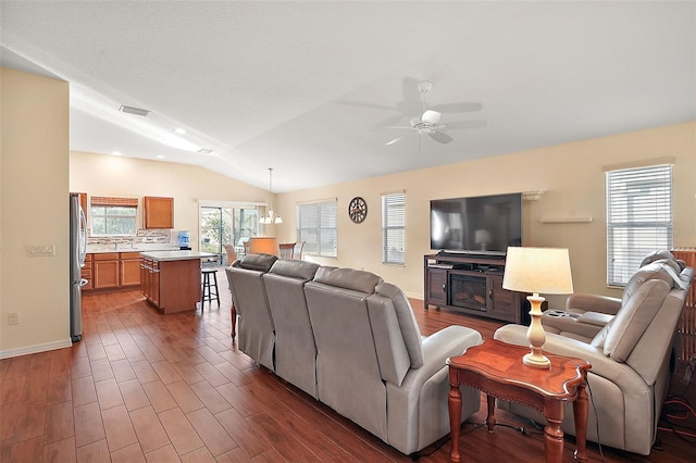 living room with ceiling fan with notable chandelier and lofted ceiling