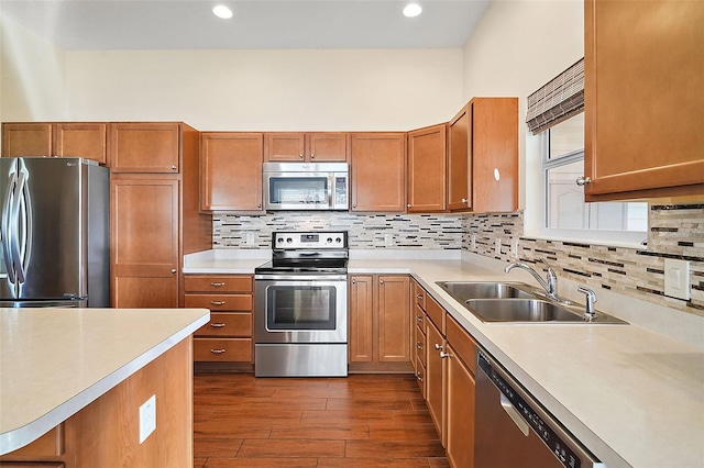 kitchen featuring backsplash, sink, stainless steel appliances, and hardwood / wood-style flooring