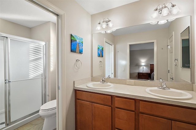 bathroom with tile patterned floors, vanity, toilet, and a shower with door