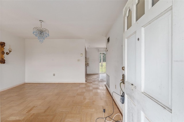 interior space with a chandelier and light parquet flooring