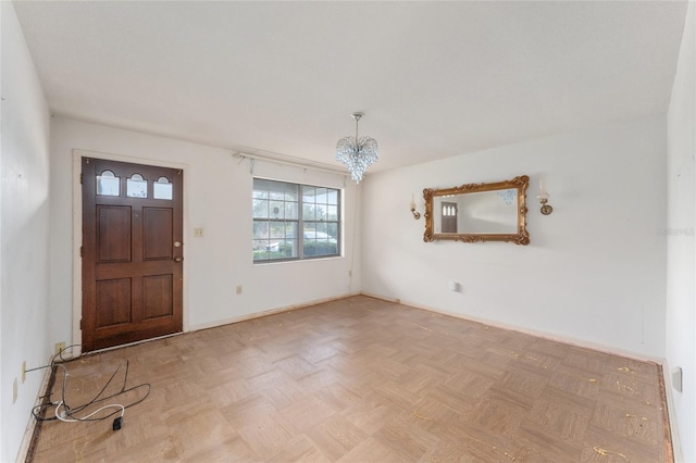 foyer with a chandelier and light parquet flooring