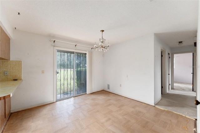 interior space featuring light parquet floors and a chandelier