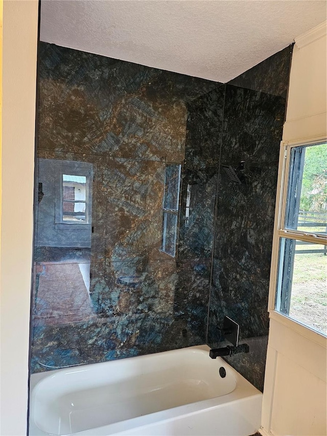 bathroom with a textured ceiling and a wealth of natural light