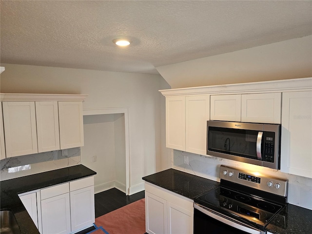 kitchen featuring white cabinets, decorative backsplash, a textured ceiling, and stainless steel appliances