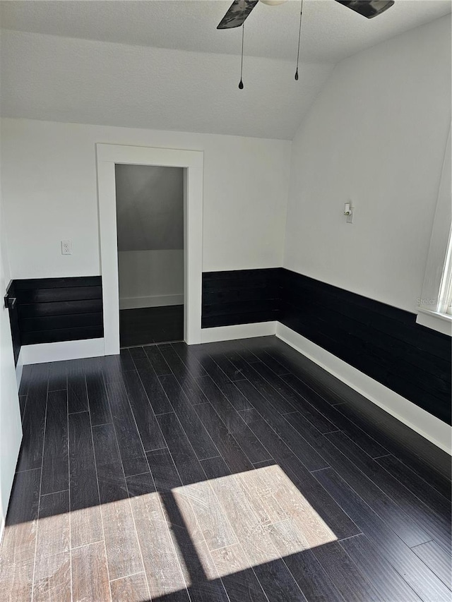 spare room featuring dark hardwood / wood-style floors, ceiling fan, and lofted ceiling