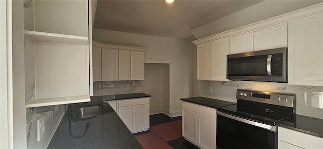 kitchen featuring a textured ceiling, stainless steel appliances, white cabinetry, and sink