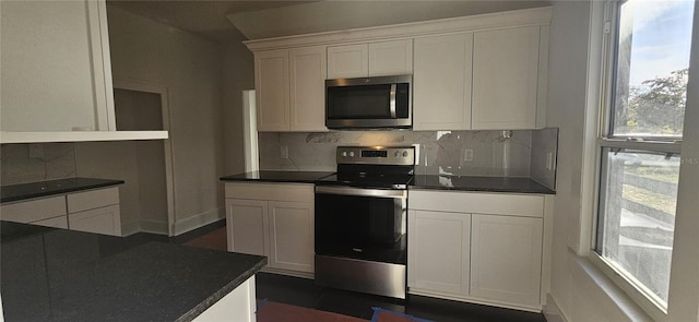 kitchen featuring white cabinets, appliances with stainless steel finishes, and tasteful backsplash