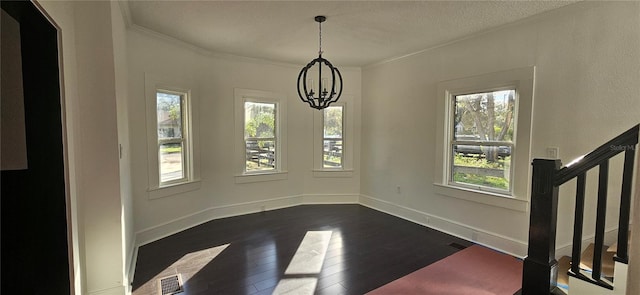 unfurnished dining area featuring ornamental molding, dark hardwood / wood-style flooring, plenty of natural light, and a notable chandelier