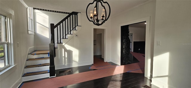 interior space featuring a chandelier, dark hardwood / wood-style flooring, and crown molding