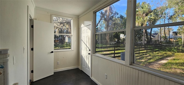 entryway featuring a textured ceiling, vaulted ceiling, and dark tile patterned flooring