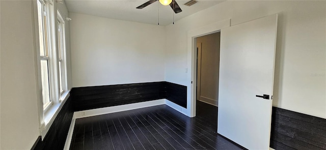 unfurnished room with ceiling fan and dark wood-type flooring