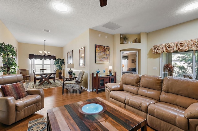 living room featuring a notable chandelier, hardwood / wood-style floors, and a textured ceiling