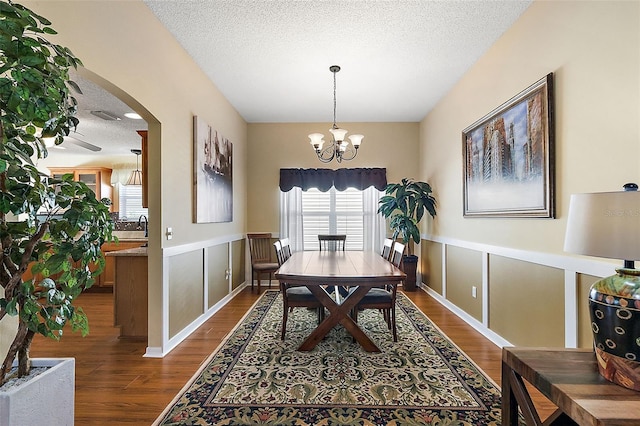 dining room featuring an inviting chandelier, dark hardwood / wood-style floors, and a textured ceiling