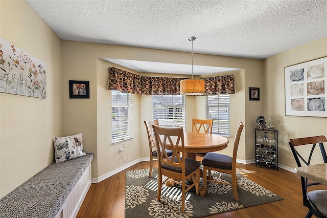 dining area featuring hardwood / wood-style flooring and a textured ceiling