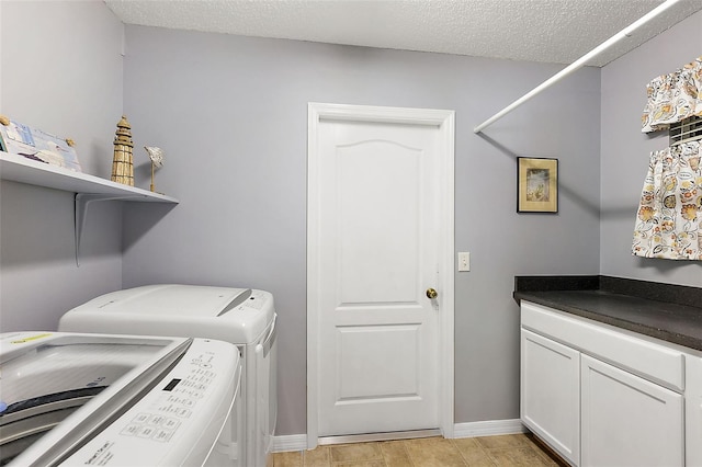 laundry room with cabinets, a textured ceiling, and washer and dryer