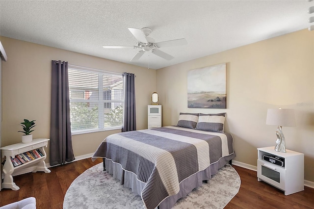 bedroom with ceiling fan, a textured ceiling, and dark hardwood / wood-style floors