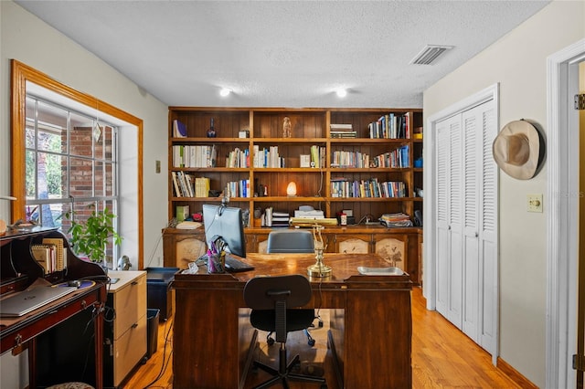 office with a textured ceiling and light hardwood / wood-style floors