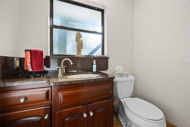 bathroom with tasteful backsplash, vanity, and toilet