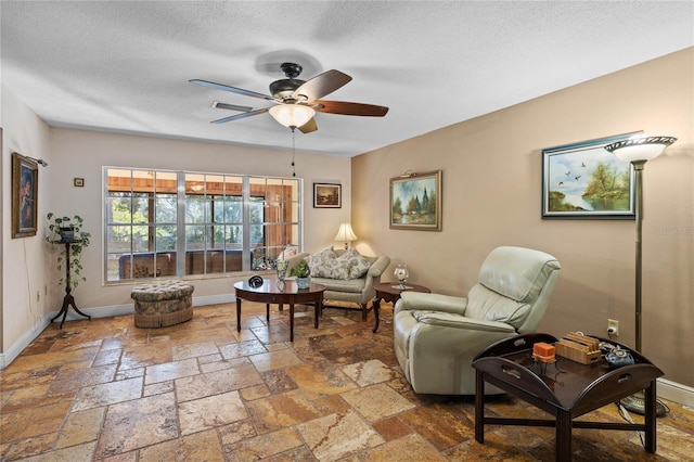 living room with ceiling fan and a textured ceiling