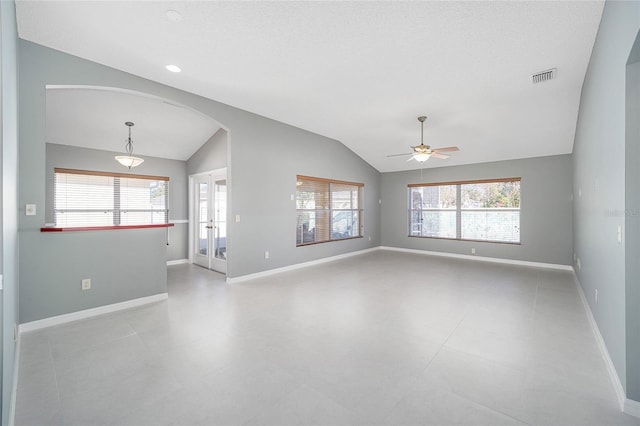 unfurnished room with vaulted ceiling, ceiling fan, a healthy amount of sunlight, and french doors