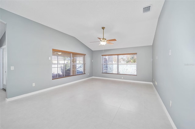 tiled spare room featuring lofted ceiling, ceiling fan, and a healthy amount of sunlight