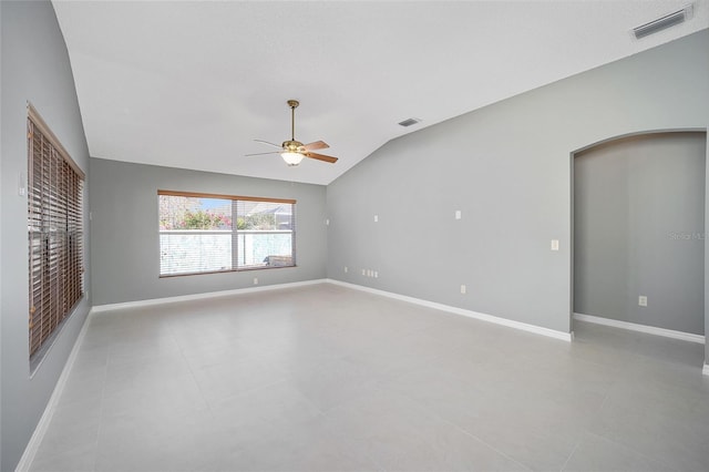 empty room featuring lofted ceiling, light tile patterned floors, and ceiling fan