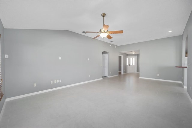 empty room with ceiling fan and vaulted ceiling