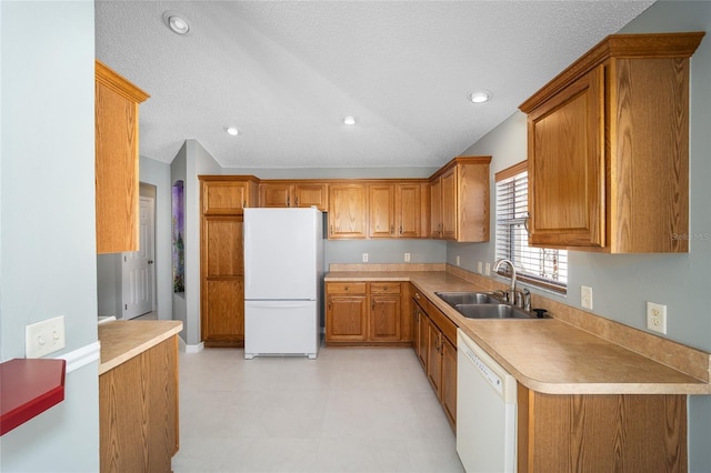 kitchen with sink, white appliances, and a textured ceiling