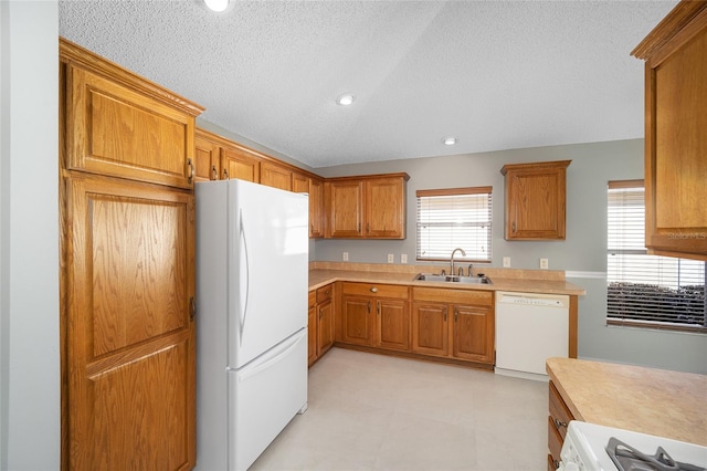 kitchen with sink, white appliances, and a textured ceiling