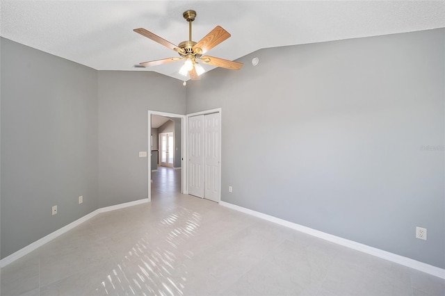 empty room with ceiling fan and lofted ceiling