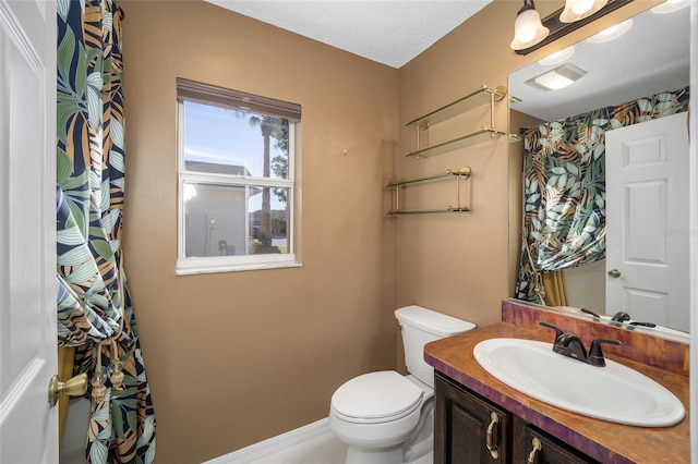 bathroom featuring toilet, vanity, and a textured ceiling