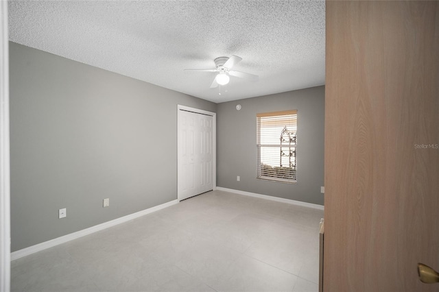 unfurnished bedroom featuring a textured ceiling, ceiling fan, and a closet