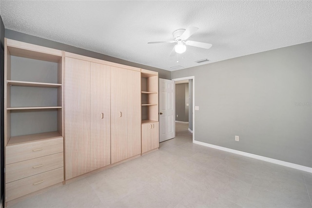 unfurnished bedroom featuring ceiling fan, a textured ceiling, and a closet