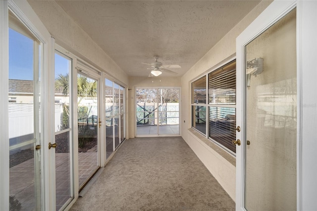 unfurnished sunroom with ceiling fan