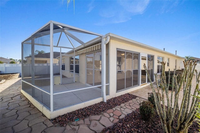 rear view of house featuring a lanai and a patio area