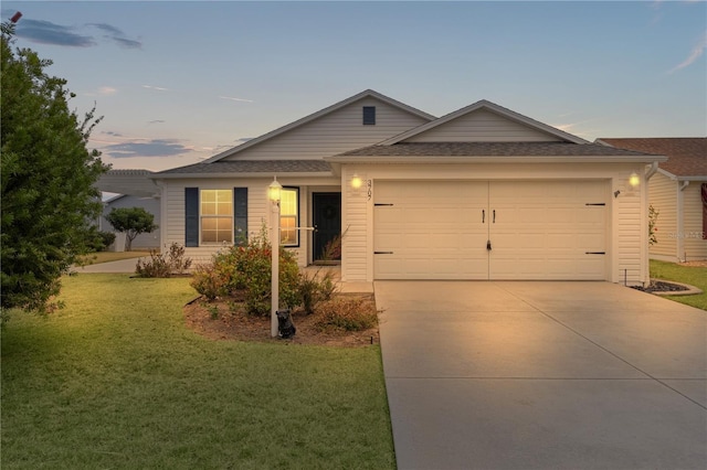 single story home featuring a garage and a lawn