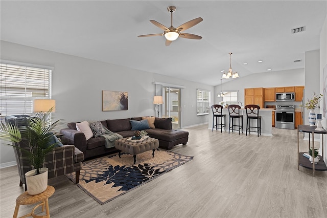 living room featuring vaulted ceiling, ceiling fan, and light wood-type flooring