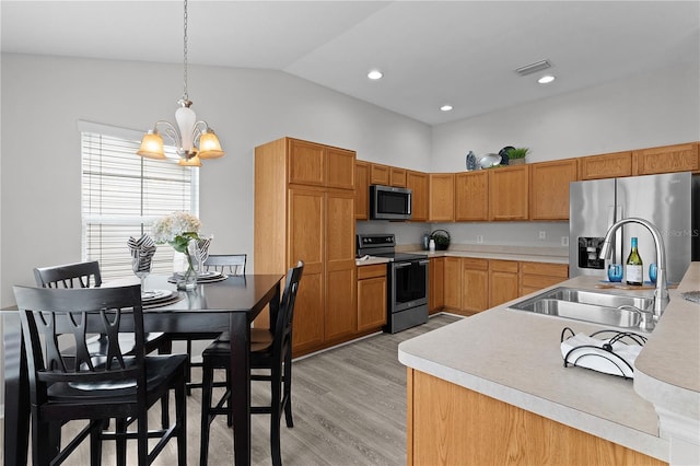 kitchen with lofted ceiling, sink, light hardwood / wood-style flooring, hanging light fixtures, and stainless steel appliances