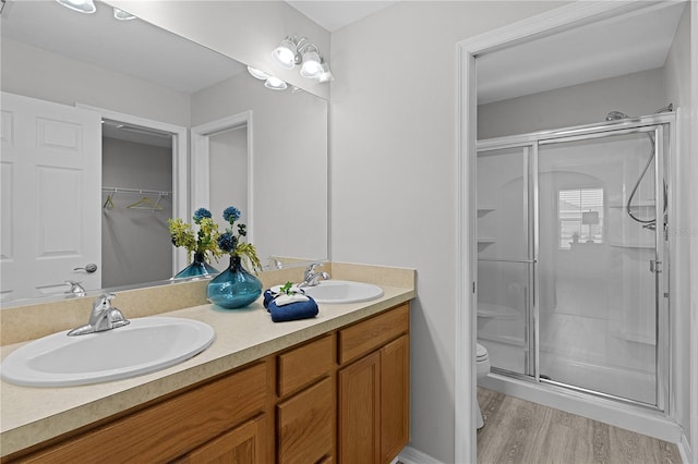 bathroom with walk in shower, wood-type flooring, toilet, and vanity