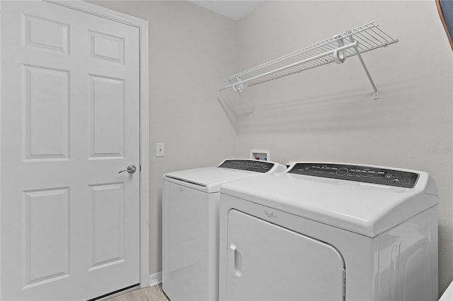 washroom featuring separate washer and dryer and light hardwood / wood-style flooring